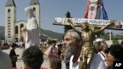 DOSSIER – Des pèlerins se promènent autour d’une statue de la Bienheureuse Vierge Marie près de l’église Saint-Jacques à Medjugorje, en Bosnie-Herzégovine, le 25 juin 2006.
